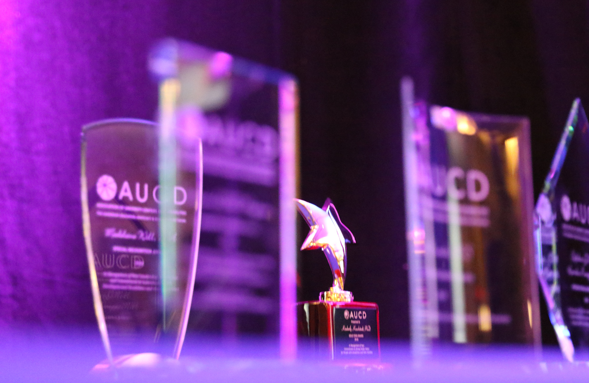 Image of a star shaped award with the AUCD banner behind it. 