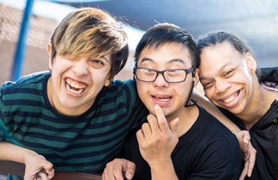 Three young adults smiling at the camera.