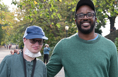 DSP provider and client standing arm in-arm in a park. 