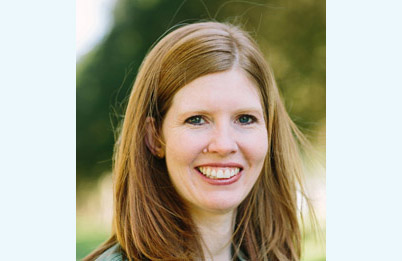 Headshot of Julie Lounds Taylor, a white woman with long brown hair wearing a blouse.