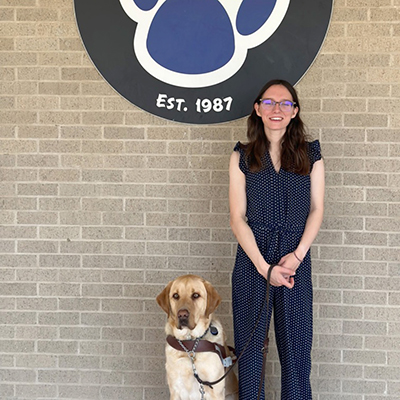 Megan Fayard standing with her service dog.