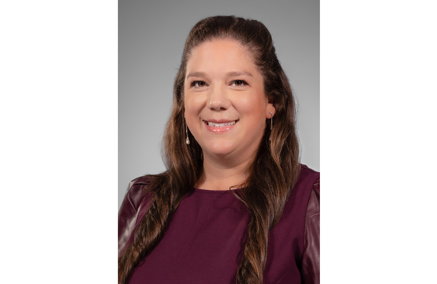 Dr. Sarah A. Nagro, A white women with long brown hair. She is wearing a blouse and jacket. 