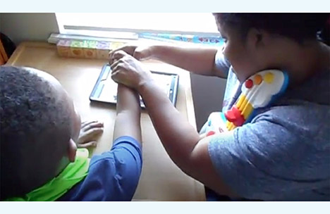 Image of mother and son using a AAC device together. 