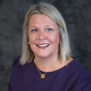 Maureen van Stone, a white woman with shoulder length blonde hair wearing a purple sweater.