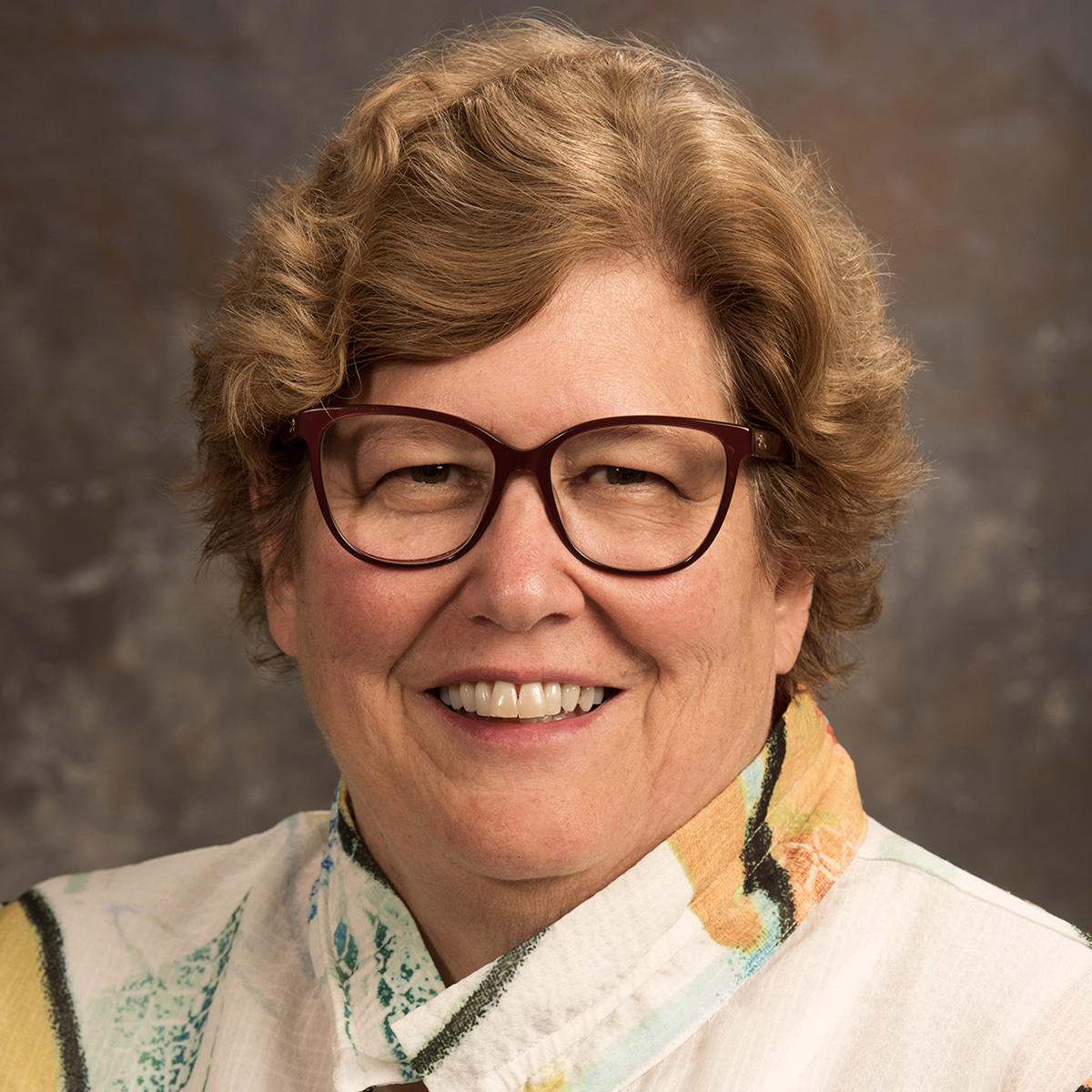 Image of Sandy Roote-Elledge, a white woman with short brown hair wearing a jacket and blouse