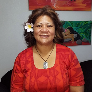 Tafaimamao Tua-Tupuola, a American Samoan woman with hair tied back wearing a red dress.