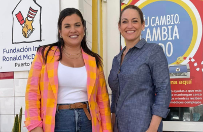  Two Latin women dressed in casual dress attire standing in front of an office building in Puerto Rico.